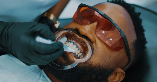 Paciente con abrebocas y gafas de protección durante una higiene dental profesional